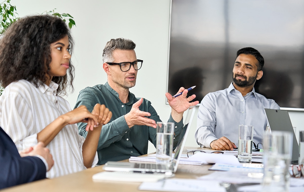 group,of,happy,coworkers,discussing,in,conference,room