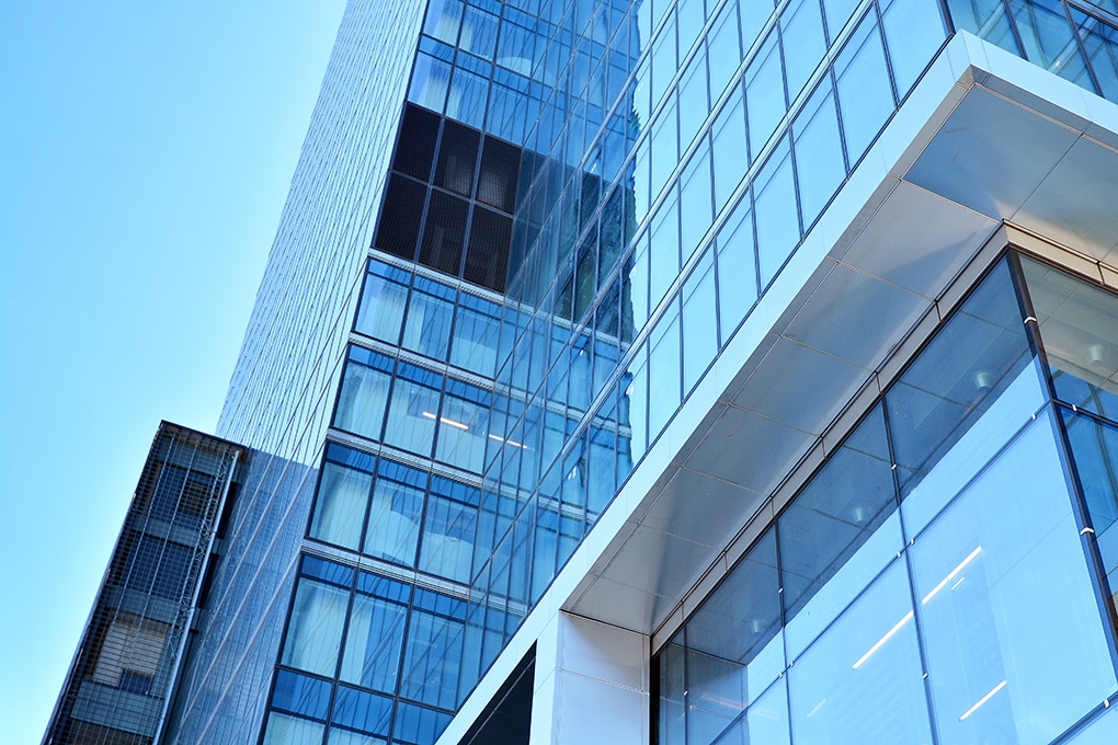 bottom,view,of,modern,skyscrapers,in,business,district,against,blue