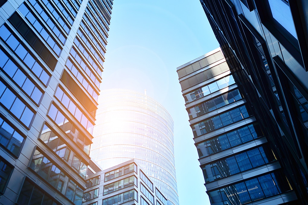 bottom,view,of,modern,skyscrapers,in,business,district,against,blue