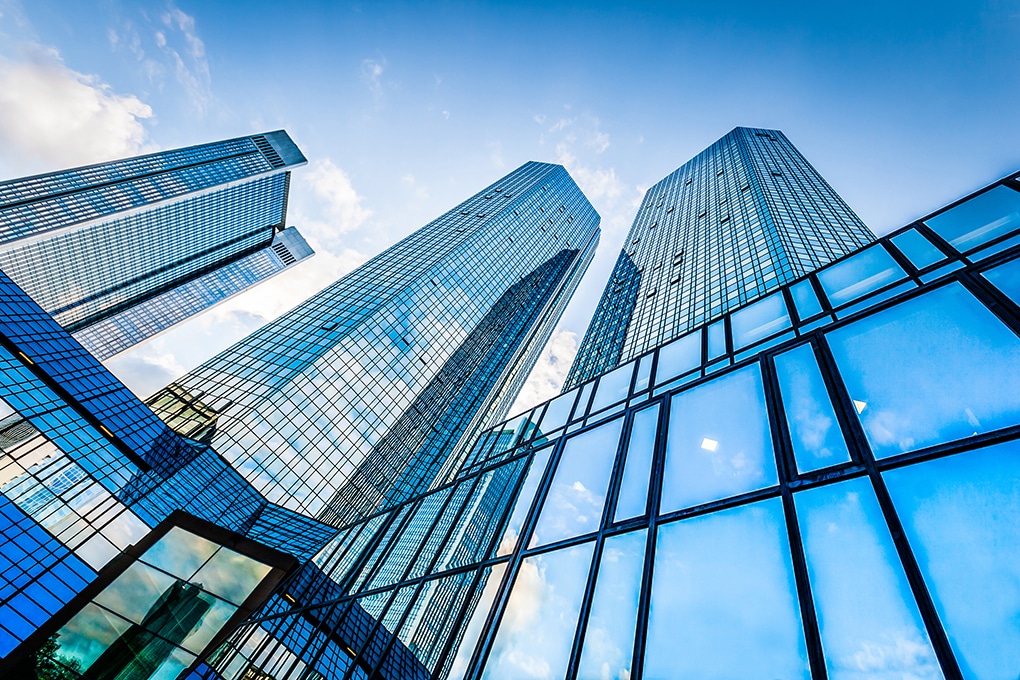 bottom,view,of,modern,skyscrapers,in,business,district,against,blue