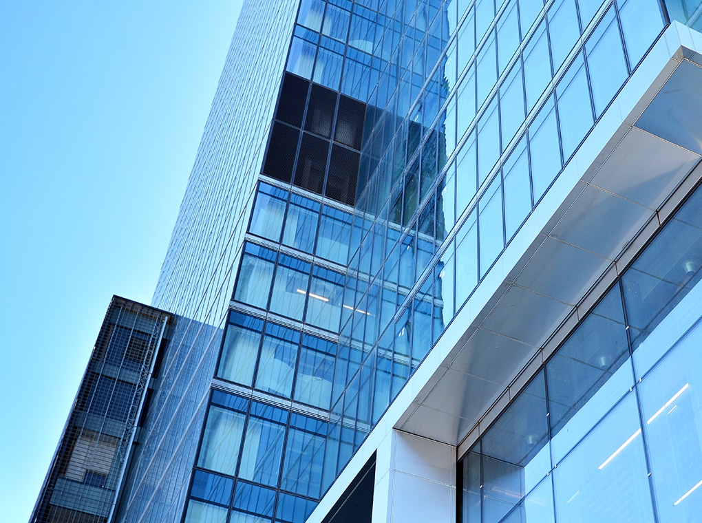 bottom,view,of,modern,skyscrapers,in,business,district,against,blue