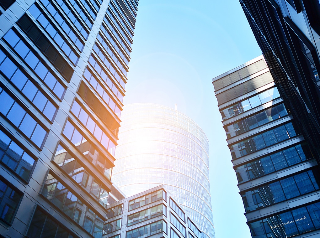 bottom,view,of,modern,skyscrapers,in,business,district,against,blue