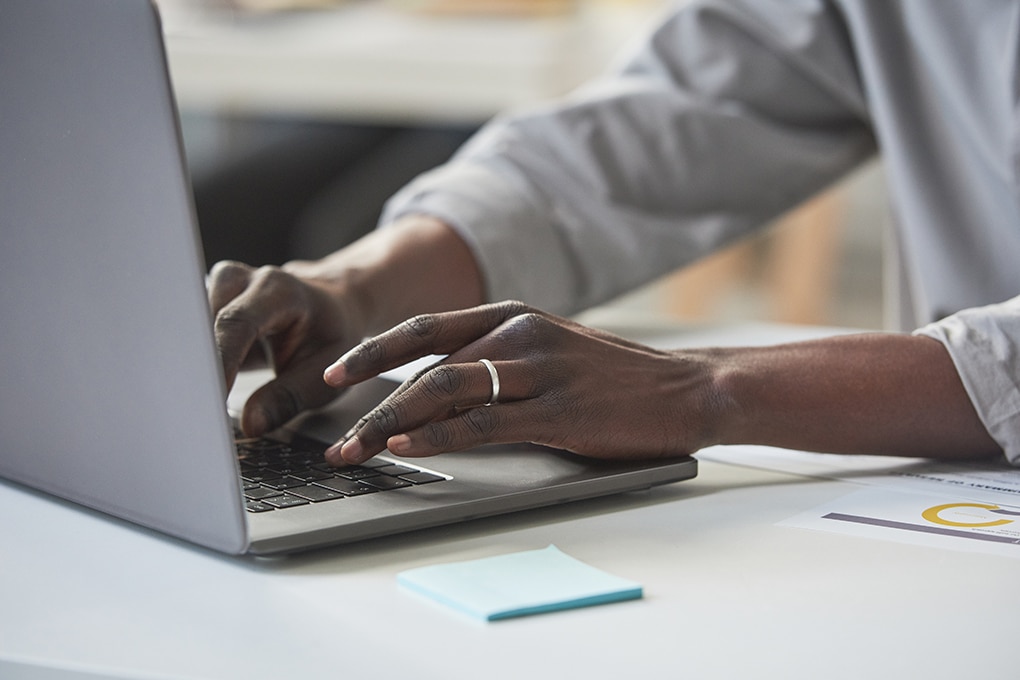 close up,of,african,businessman,sitting,at,the,table,and,typing