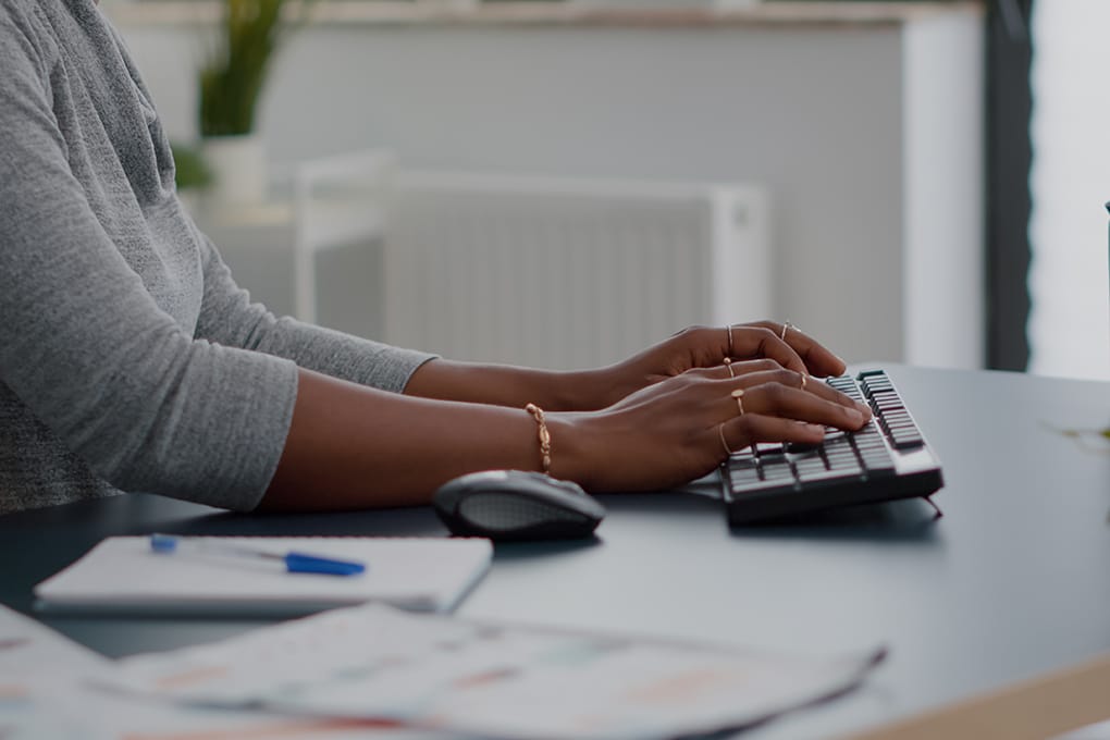 close up,of,teenager,with,dark,skin,hands,on,keyboard,typing