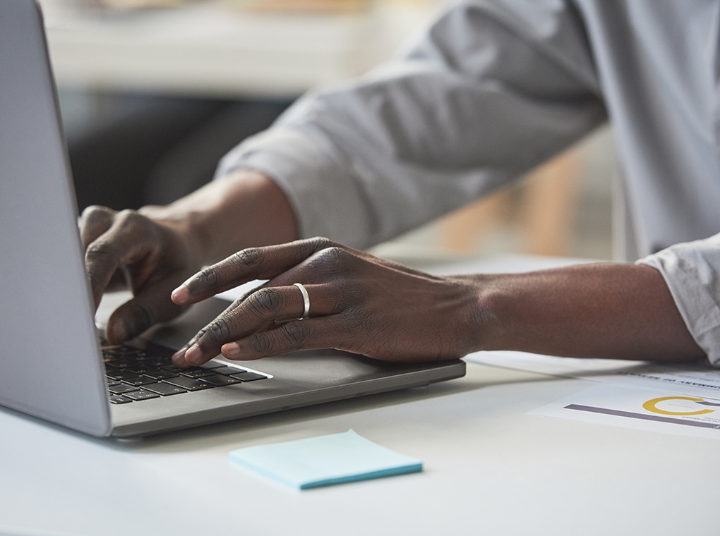 close up,of,african,businessman,sitting,at,the,table,and,typing