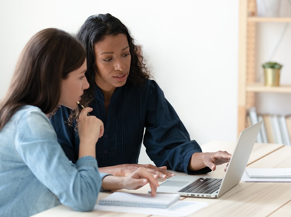 focused,diverse,female,colleagues,sit,at,desk,in,office,brainstorm